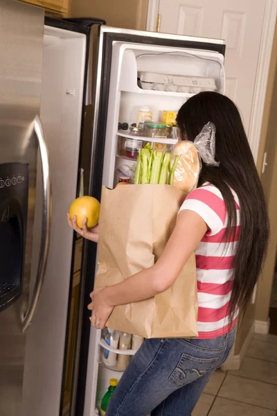 Женщина убирает свои продукты — стоковое фото