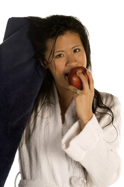 Woman drying her hair while enjoying an apple. — Stock Photo, Image