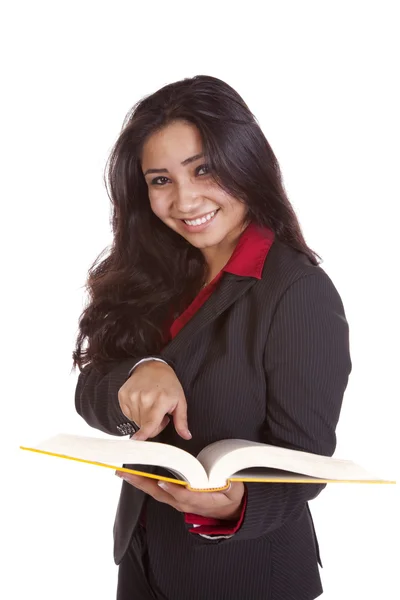 Girl pointing in book smiling — Stock Photo, Image