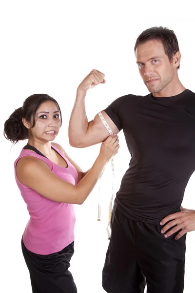 Mujer sorprendida al medir el brazo de los hombres —  Fotos de Stock