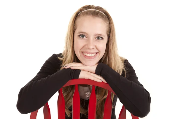 Flicka röd stol leende bakåt — Stockfoto