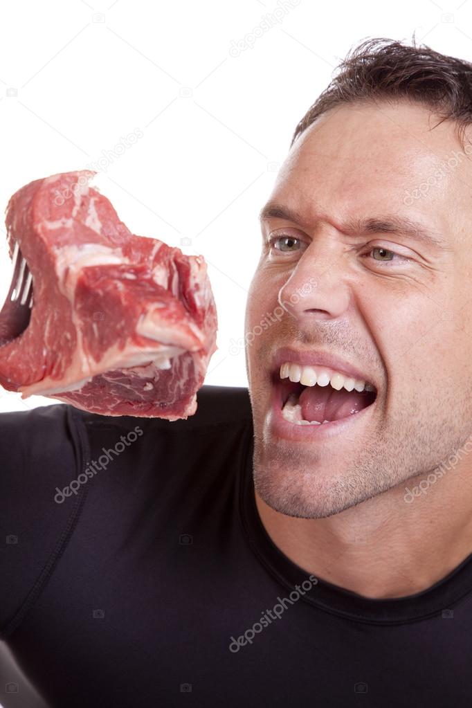 Man eating raw steak