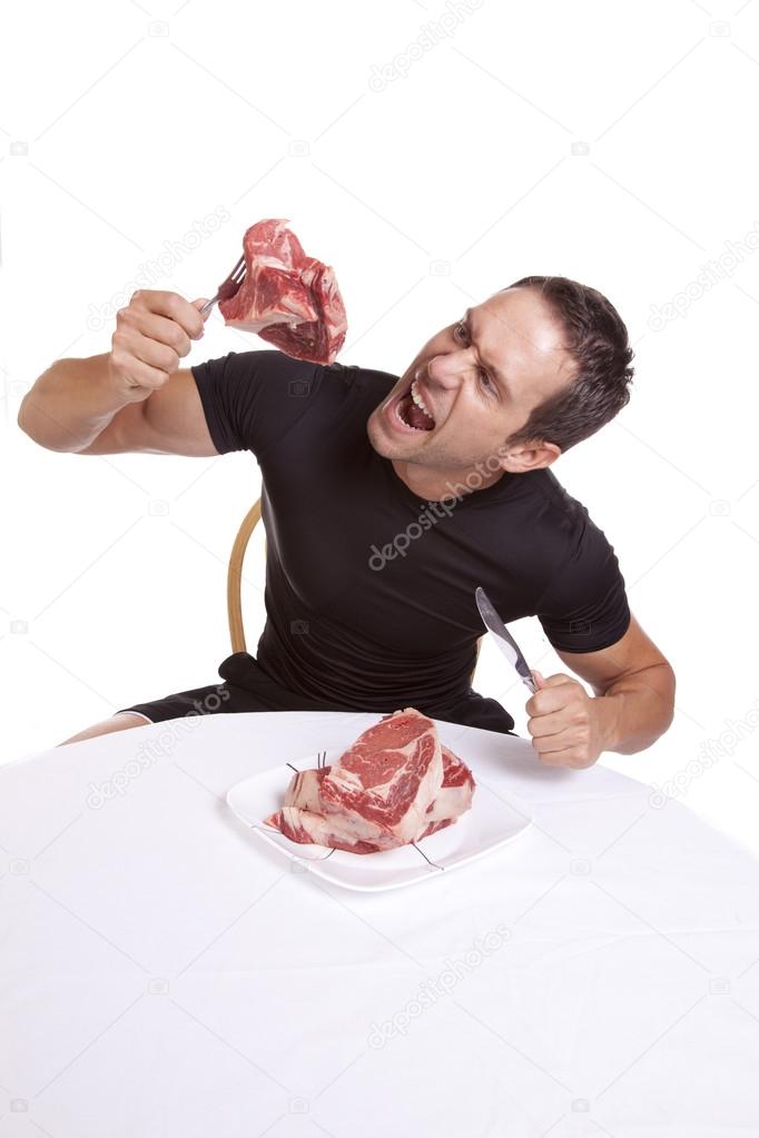 Man with raw steak eating