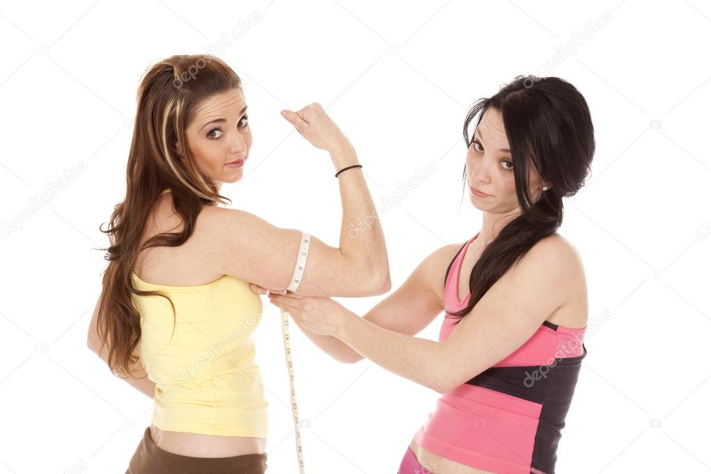 Lady measuring anothers bicept