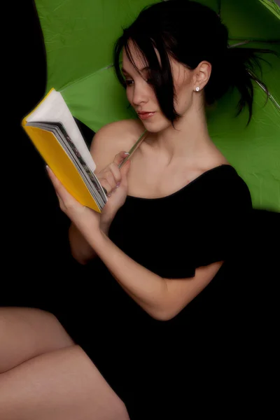Kobieta czytająca pod zielony parasol — Zdjęcie stockowe