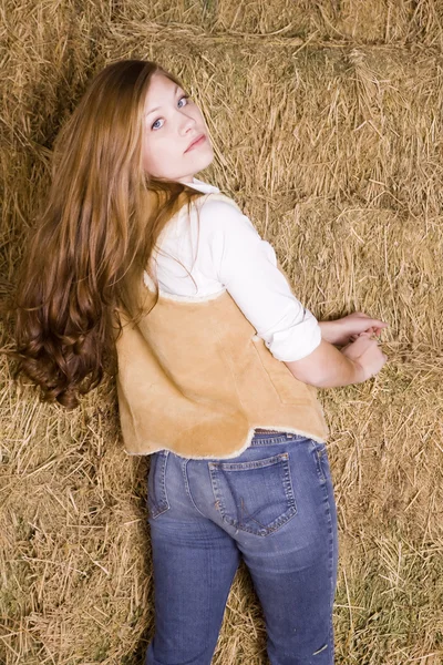 Woman looking over shoulder by hay serious — Stock Photo, Image