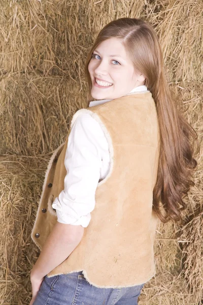 Woman looking over shoulder by hay smiling — Stock Photo, Image