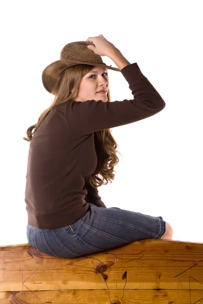 Woman on back of bench holding hat — Stock Photo, Image