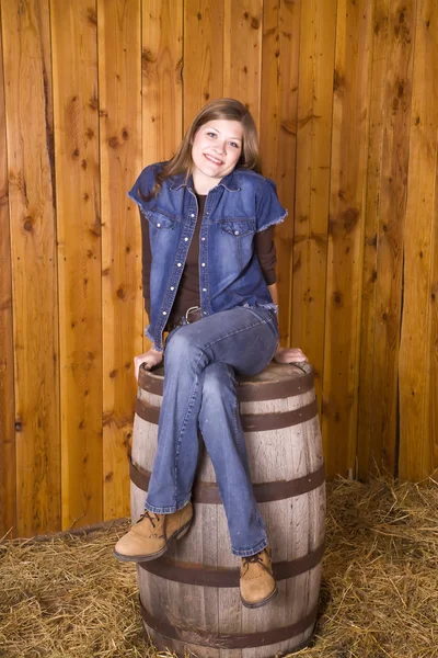 Woman on barrel legs crossed — Stock Photo, Image