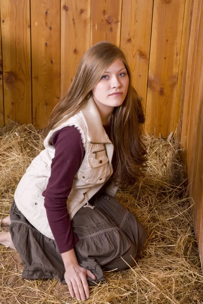 Woman sitting in hay serious — Stock Photo, Image