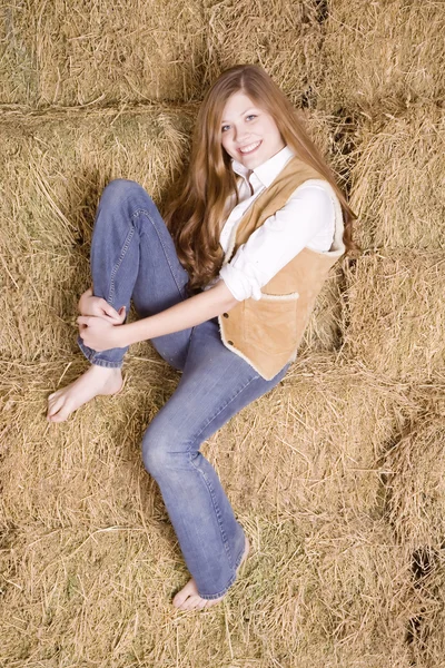 Woman sitting on haystack leg — Stock Photo, Image