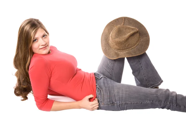 Femme souriante en rouge et avec un chapeau sur le genou — Photo