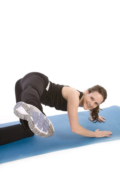 Mulher exercitando e chutando a perna — Fotografia de Stock