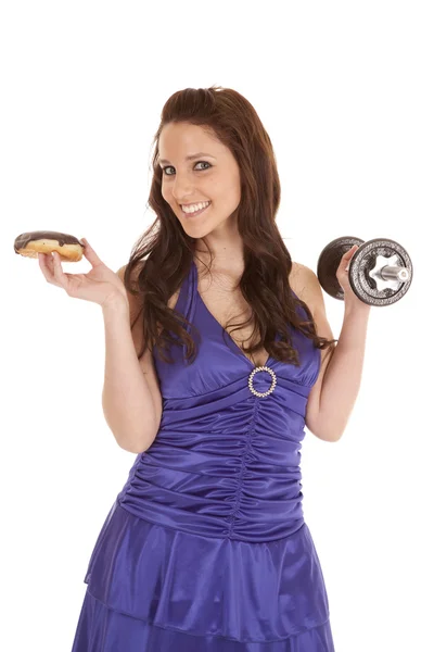 Mujer azul vestido pesos sonrisa en donut —  Fotos de Stock