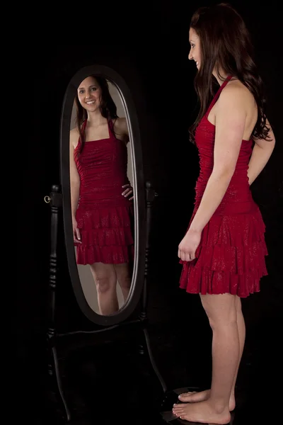 Mulher em escalas olhando espelho vermelho — Fotografia de Stock