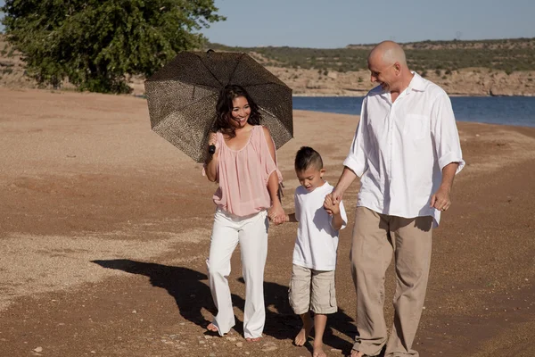 Paraguas de playa familiar a pie — Foto de Stock