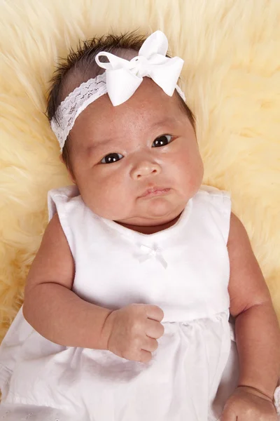 Bebê oriental que põe em um tapete de pele — Fotografia de Stock