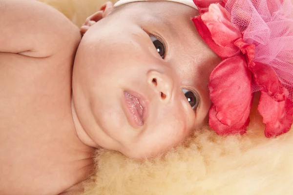 Baby in a pink lacy out fit with pink flower — Stock Photo, Image