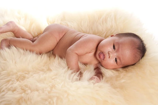 Bebê oriental que põe em um tapete de pele — Fotografia de Stock