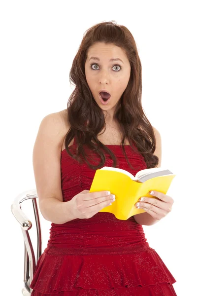Woman red dress shocked at book Stock Picture