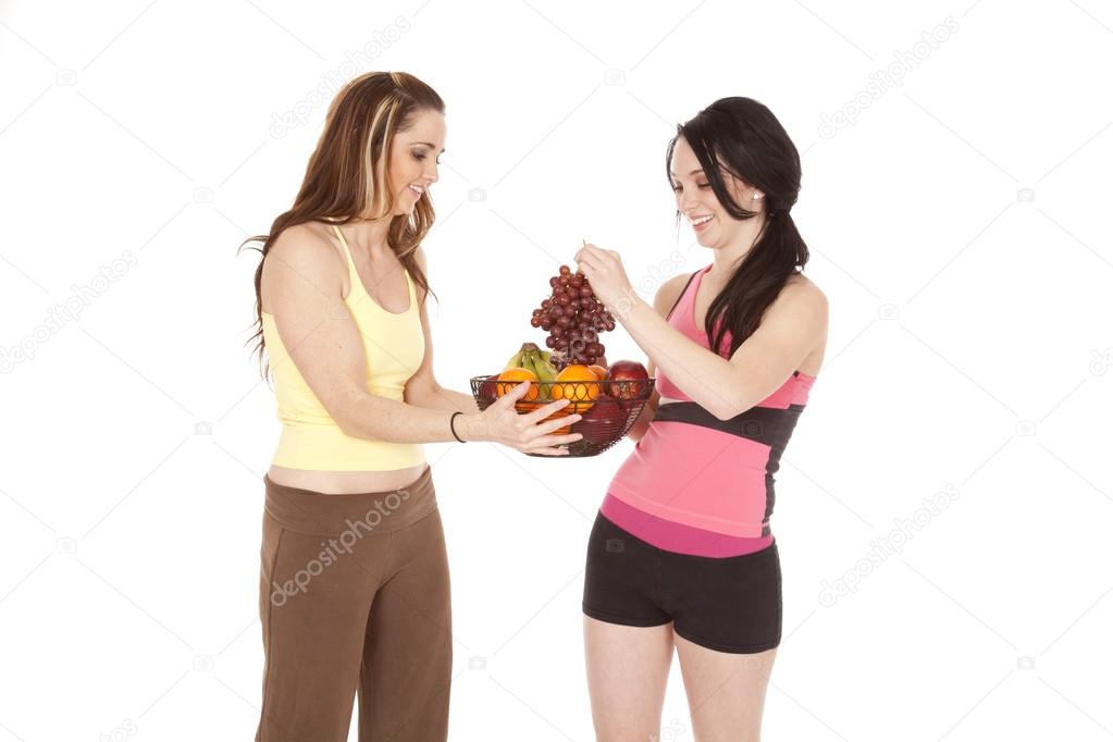 two women one holding grapes