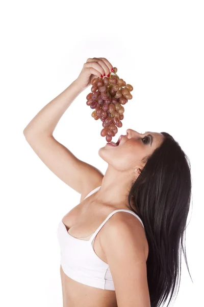Biustonosz sportowy kobieta jedzenie winogron — Zdjęcie stockowe