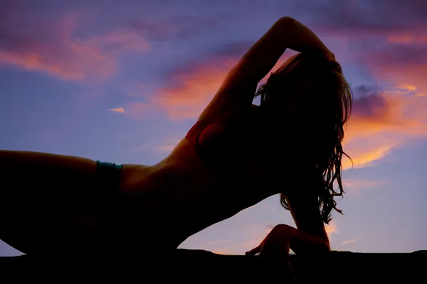 Woman silhouette lay side close sunset — Stock Photo, Image