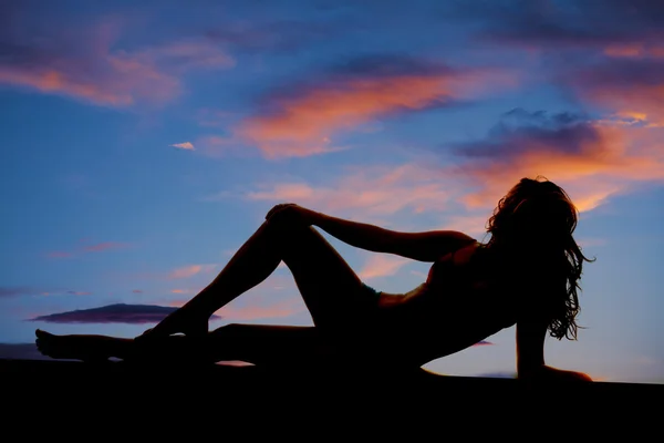 Woman silhouette lay side sunset — Stock Photo, Image