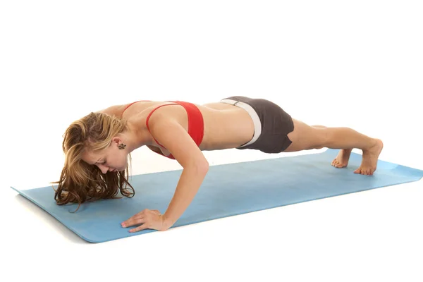 Woman red sports bra doing a pushup — Stock Photo, Image