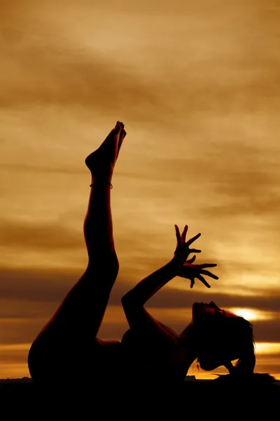 Silhouette fitness lay back legs up hands fanned — Stock Photo, Image