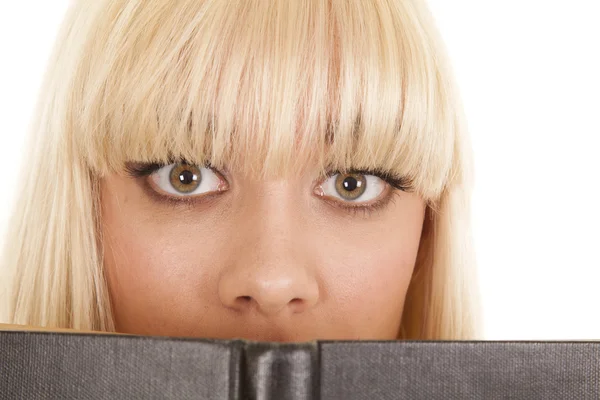 Vrouw ogen breed over boek Stockfoto