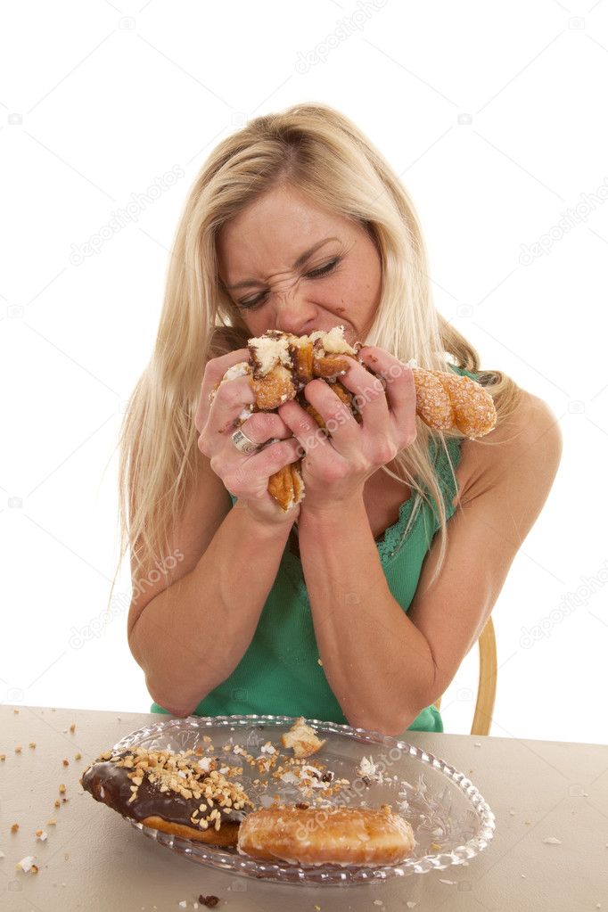 Woman stuffing doughnuts onto mouth