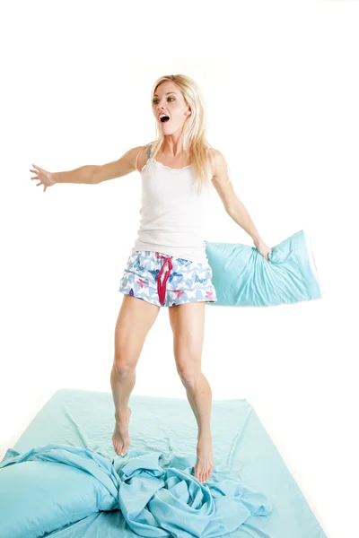 Woman jump on bed hold pillow — Stock Photo, Image