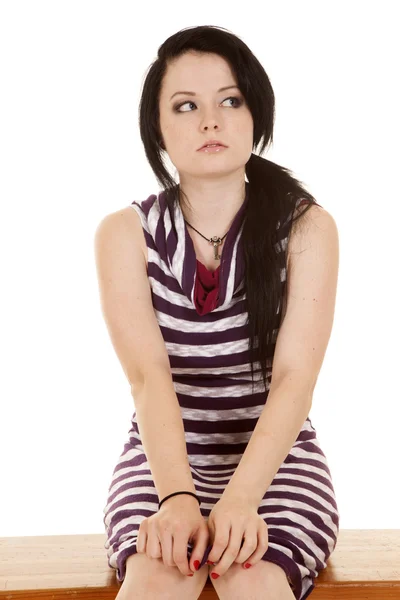 Kobieta pasiasty strój purpurowy siedzieć naprzeciwko wygląd strony — Zdjęcie stockowe