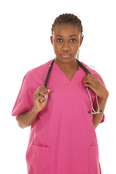 Медсестра в рожевому кольорі зі стетоскопом серйозно — стокове фото