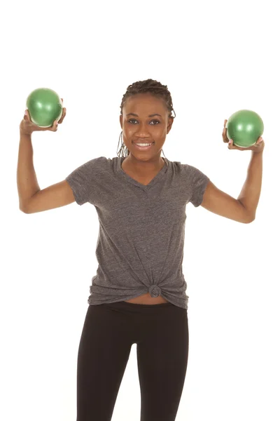 Mulher em camisa cinza fitness bolas verdes para cima — Fotografia de Stock