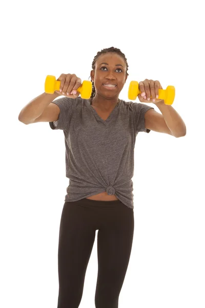 Mujer en gris camisa fitness amarillo pesos empujar hacia fuera — Foto de Stock