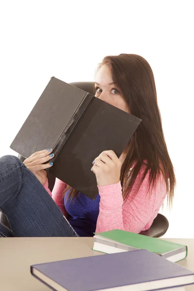 Sosteniendo libro a cara mirando sobre adolescente — Foto de Stock