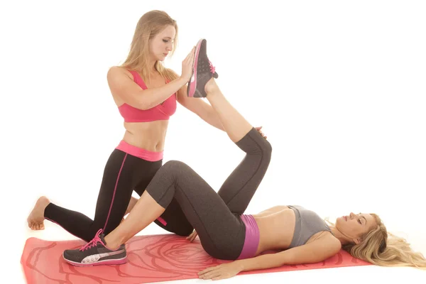 Woman stretch another woman 's leg — стоковое фото