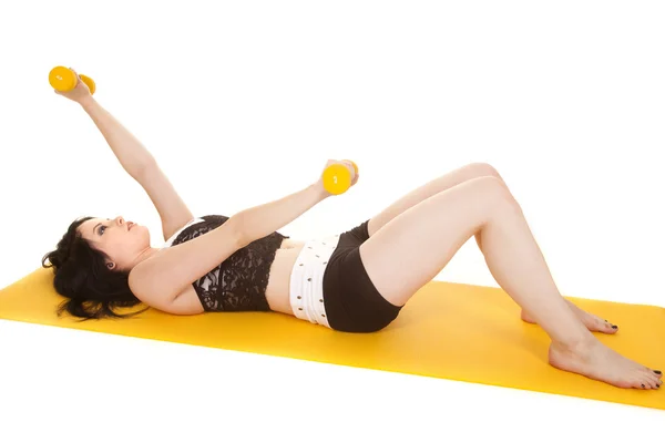 Woman fitness yellow mat lay weights — Stock Photo, Image