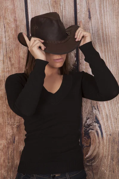 Woman cowgirl wooden wall hands on hat — Stock Photo, Image
