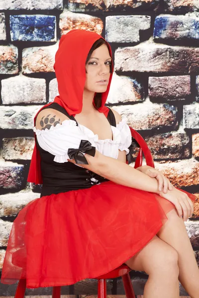 Kobieta czerwona peleryna tatuaż pazur siedzieć blisko — Zdjęcie stockowe