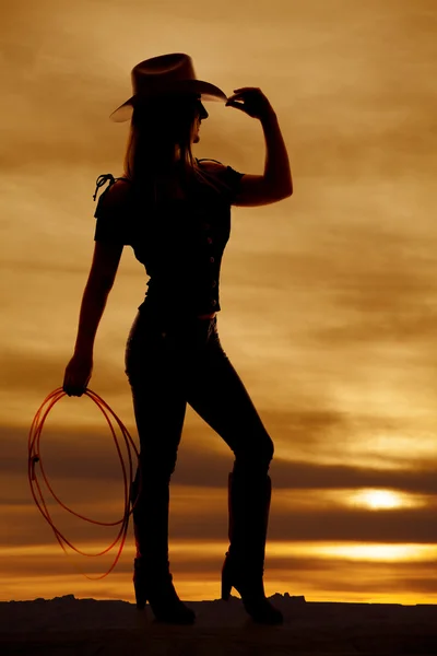 Silhouette cowgirl hold rope touch hat — Stock Photo, Image