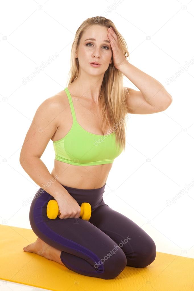 woman kneel green sports bra hand head