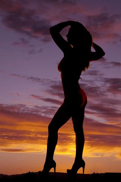 Silhuett kvinna bikini klackar sida händer hår — Stockfoto