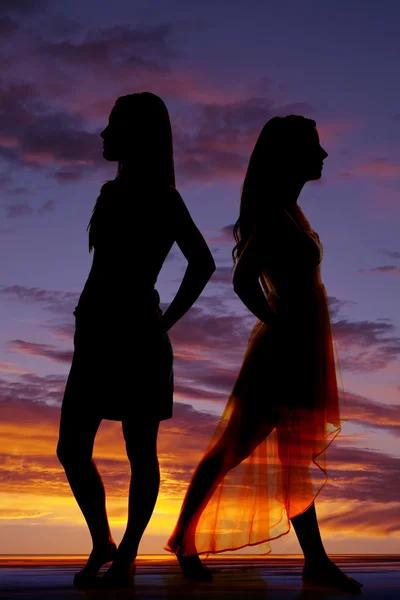Silhouette two women stand back to back