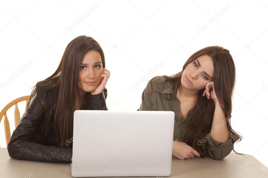 Two women computer one smile one serious
