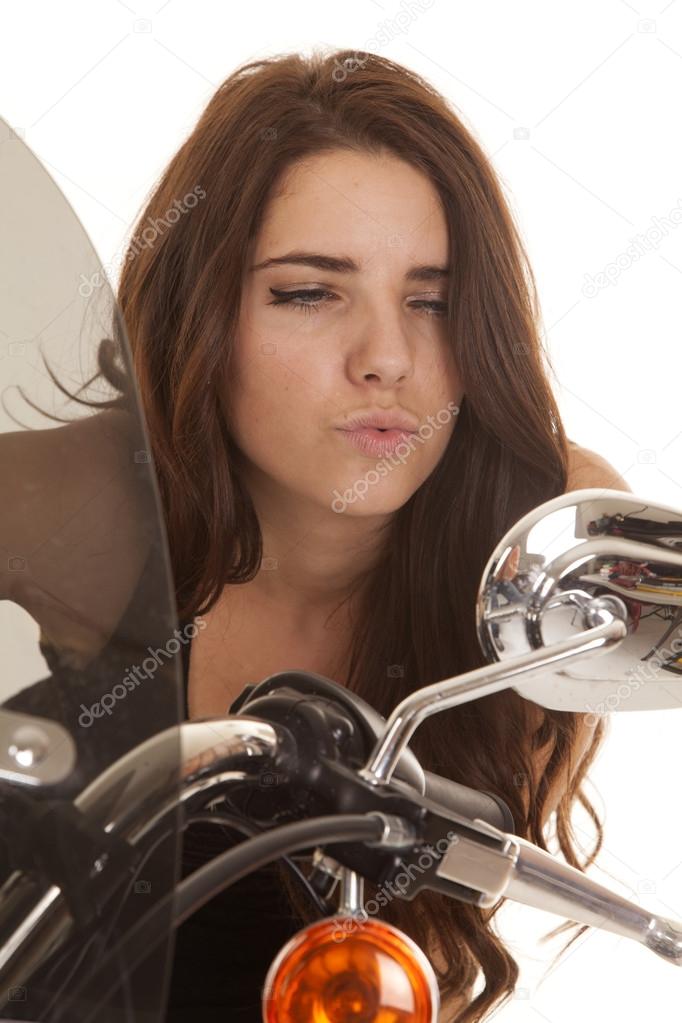Woman in black stand by motorcycle look mirror