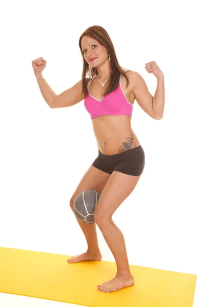 Woman pink bra shorts fitness ball between legs flex Royalty Free Stock Photos
