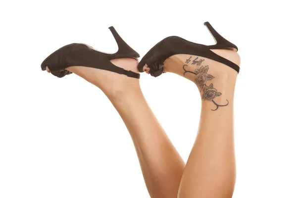 Woman legs tattoo on foot heels up — Stock Photo, Image